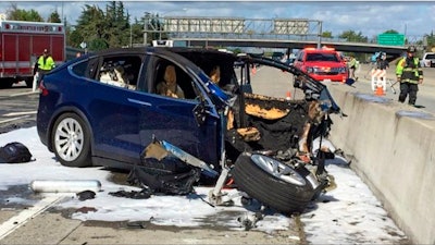 In this March 23, 2018, file photo, emergency personnel work at the scene of a Tesla crash on U.S. Highway 101, Mountain View, Calif.