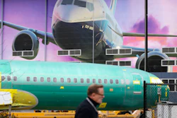 A Boeing worker walks past a 737 model fuselage and mural in Renton, Wash., Dec. 16, 2019.