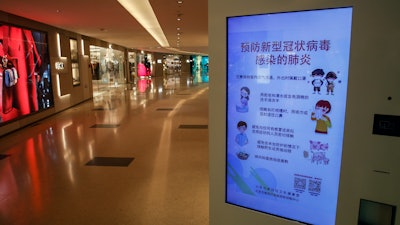 In this Feb. 9, 2020, file photo, an electronic display board shows a precautionary notice of the coronavirus at a deserted upscale shopping mall in Beijing.