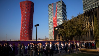 Attendees walk to enter the Mobile World Congress wireless show in Barcelona, Feb. 25, 2019.