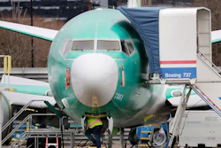 In this Dec. 16, 2019, file photo, a worker looks up underneath a Boeing 737 Max jet in Renton, Wash.