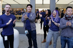 Apple employees greet customers as they wait to enter the Union Square store in San Francisco, Nov. 3, 2017.