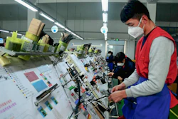 Masked workers assemble auto wiring at a factory in Qingdao, China, Feb. 13, 2020.