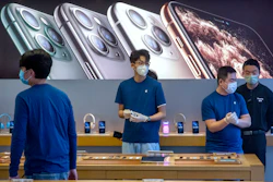 Employees wear face masks as they stand in a reopened Apple Store in Beijing, Feb. 14, 2020.