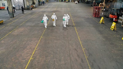 Workers spray disinfectant at Agricultural and Wholesale Products Center, Daegu, South Korea, Feb. 20, 2020.