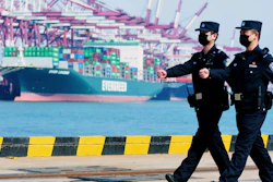Police officers wearing face masks patrol at a container port in Qingdao, China, Feb. 19, 2020.