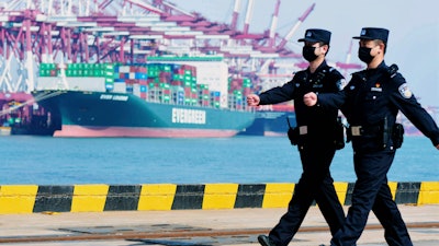 Police officers wearing face masks patrol at a container port in Qingdao, China, Feb. 19, 2020.