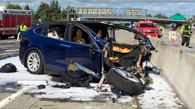 Emergency personnel work at the scene where a Tesla SUV crashed into a barrier on U.S. Highway 101 in Mountain View, Calif., March 23, 2018.