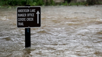 Sign is submerged in water from Coyote Creek, Morgan Hill, Calif., Feb. 21, 2017.