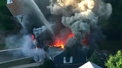 Flames consume the roof of a home following an explosion in Lawrence, Mass., Sept. 13, 2018.