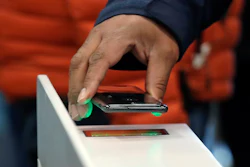 A shopper scans a cellphone app while entering an Amazon Go store in Seattle, Jan. 22, 2018.