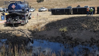 Workers monitor the site of an underground oil pipeline break near Refugio State Beach, north of Goleta, Calif., May 20, 2015.