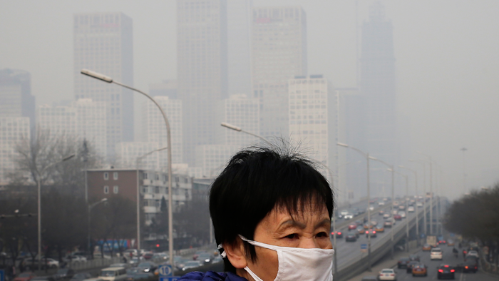 A woman walks on a pedestrian bridge in Beijing, Dec. 20, 2015.
