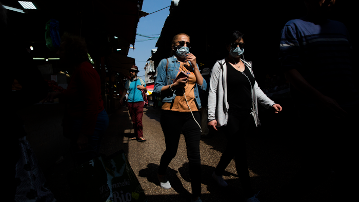 People wear face masks at a food market in Tel Aviv, March 15, 2020.