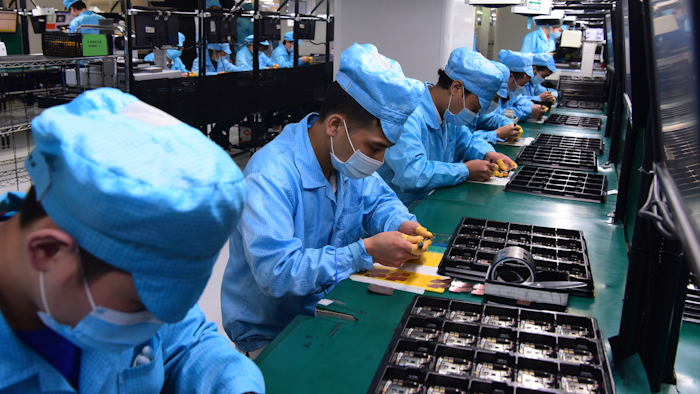 Workers wear masks at a factory for telecom company OPPO in Dongguan, China, Feb. 13, 2020.