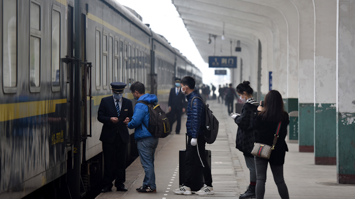 Passengers board a train at the Jingmen Railway Station in Jingmen, China, March 25, 2020.