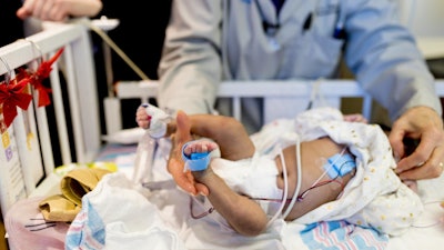 A neonate wears wireless sensors (in blue) and traditional, wired sensors in an evaluation at Prentice Women's Hospital in Chicago.