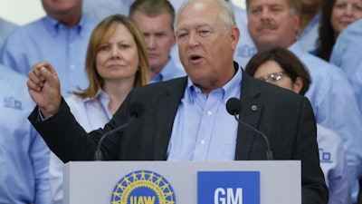 United Auto Workers President Dennis Williams speaks as General Motors CEO Mary Barra, background left, listens during a ceremony to mark the opening of contract negotiations in Detroit, July 13, 2015.