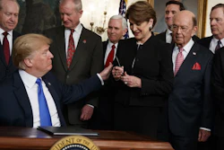 President Donald Trump hands a pen to Lockheed Martin CEO Marillyn Hewson after signing a memorandum imposing tariffs and investment restrictions on China, March 22, 2018, in the White House.