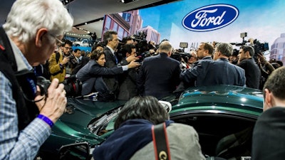 Members of the media interview Jim Hackett, president and CEO of Ford, in front the 2019 Mustang Bullitt at the North American International Auto Show, Jan. 14, 2018, in Detroit.