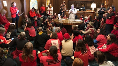 Demonstrators against a proposed liquid-natural gas pipeline and export terminal sit in in the governor's office in Salem, Ore., Nov. 21, 2019.