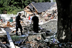 Fire investigators search debris at a home which exploded following a gas line failure in Lawrence, Mass., Sep. 21, 2018.