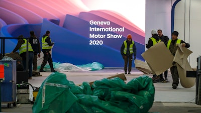 Workers dismantle a booth after the 90th Geneva International Motor Show is cancelled by Swiss authorities, Feb. 28, 2020.