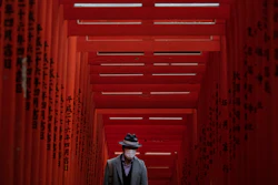 A man with a mask walk through torii gates at the Hie Shrine In Tokyo, March 1, 2020.