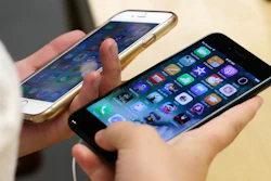 A customer holds an iPhone 6 and iPhone 7 at an Apple Store in Chicago, Sept. 16, 2016.