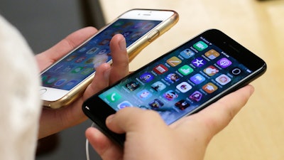 A customer holds an iPhone 6 and iPhone 7 at an Apple Store in Chicago, Sept. 16, 2016.