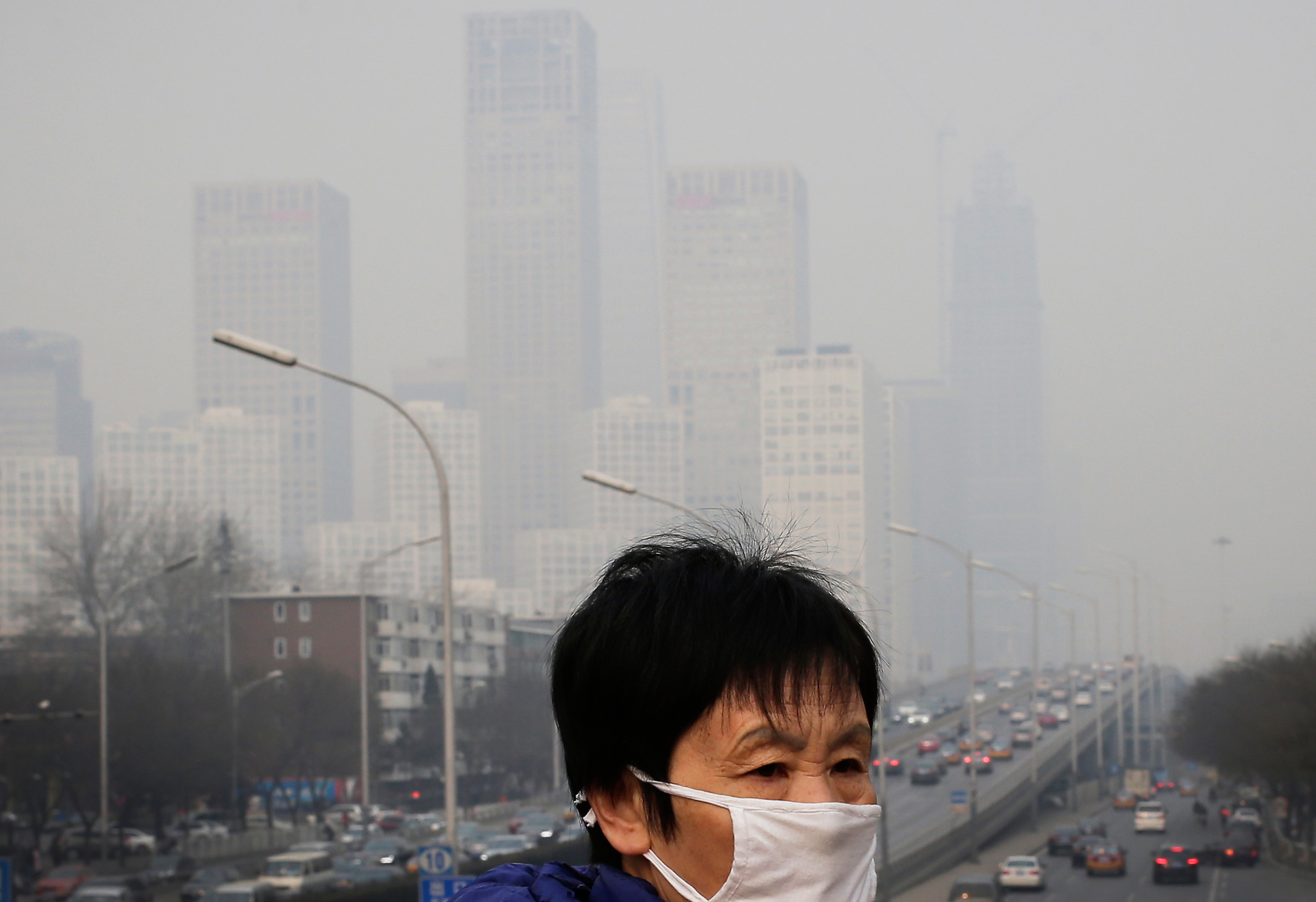 A woman walks on a pedestrian bridge in Beijing, Dec. 20, 2015.