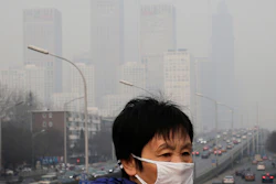 A woman walks on a pedestrian bridge in Beijing, Dec. 20, 2015.