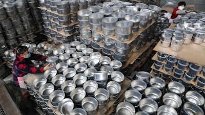 Workers arrange stew pots at a factory in Hangzhou, China, Feb. 27, 2020.