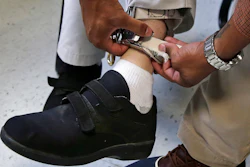 A therapist checks the ankle strap of an electrical shocking device on a student during an exercise program at the Judge Rotenberg Educational Center in Canton, Mass., Aug. 13, 2014.