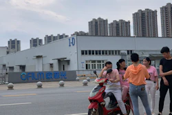 Residents chat near the entrance to an OFILM factory in Nanchang, China, June 5, 2019.