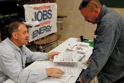A recruiter in the shale gas industry speaks with an attendee of a job fair in Cheswick, Pa., Nov. 2, 2017.