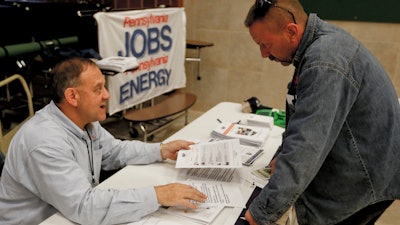 A recruiter in the shale gas industry speaks with an attendee of a job fair in Cheswick, Pa., Nov. 2, 2017.