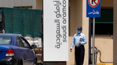 A security person wears a mask as he checks vehicles entering a compound for Saudi Aramco in Jiddah, Saudi Arabia, March 9, 2020.