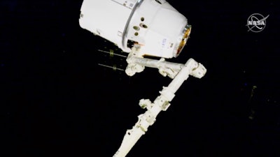 NASA astronauts Andrew Morgan and Jessica Meir use the International Space Station's robot arm to capture the Dragon capsule, March 9, 2020.