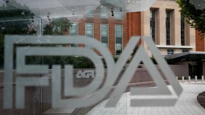 The U.S. Food and Drug Administration building behind FDA logos at a bus stop in Silver Spring, Md., Aug. 2, 2018.
