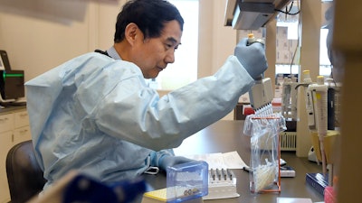 Microbiologist Xiugen Zhang runs a test at the Connecticut State Public Health Laboratory in Rocky Hill, Conn., March 2, 2020.