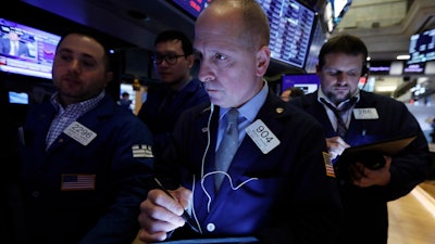 Trader Michael Urkonis, center, works on the floor of the New York Stock Exchange, March 10, 2020.