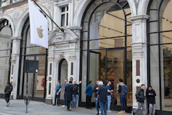 Staff members stand outside of a London Apple Store informing people of its closure, March 14, 2020.