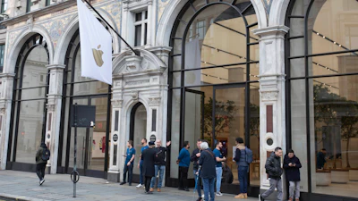 Staff members stand outside of a London Apple Store informing people of its closure, March 14, 2020.
