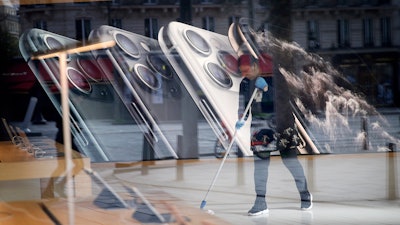 A worker cleans the Apple Store on the Champs-Elysees avenue in Paris, March 15, 2020.