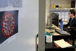 Dr. Lisa Jackson, a senior investigator at the Kaiser Permanente Washington Health Research Institute, works in her office with an image of COVID-19 taped to her door, March 15, 2020, in Seattle.