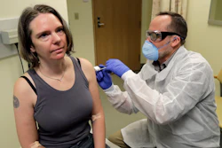 A pharmacist gives Jennifer Haller the first shot in the clinical trial of a potential vaccine for COVID-19, March 16, 2020, at the Kaiser Permanente Washington Health Research Institute in Seattle.