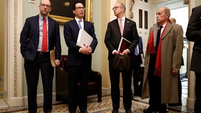 Treasury Secretary Steve Mnuchin, second from left, speaks as he departs a meeting with Senate Republicans on Capitol Hill, March 16, 2020.