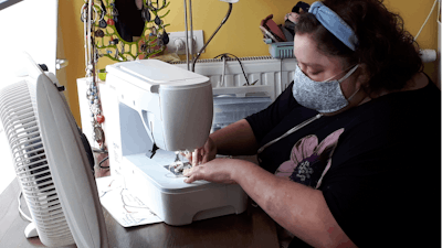 Sien Lagae works on a mouth mask on her sewing machine in Torhout, Belgium, March 19, 2020.
