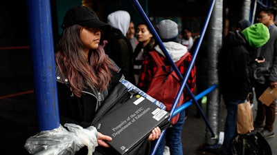 Anna Louisa, 18, receives a laptop for home study at the Lower East Side Preparatory School in New York, March 19, 2020.